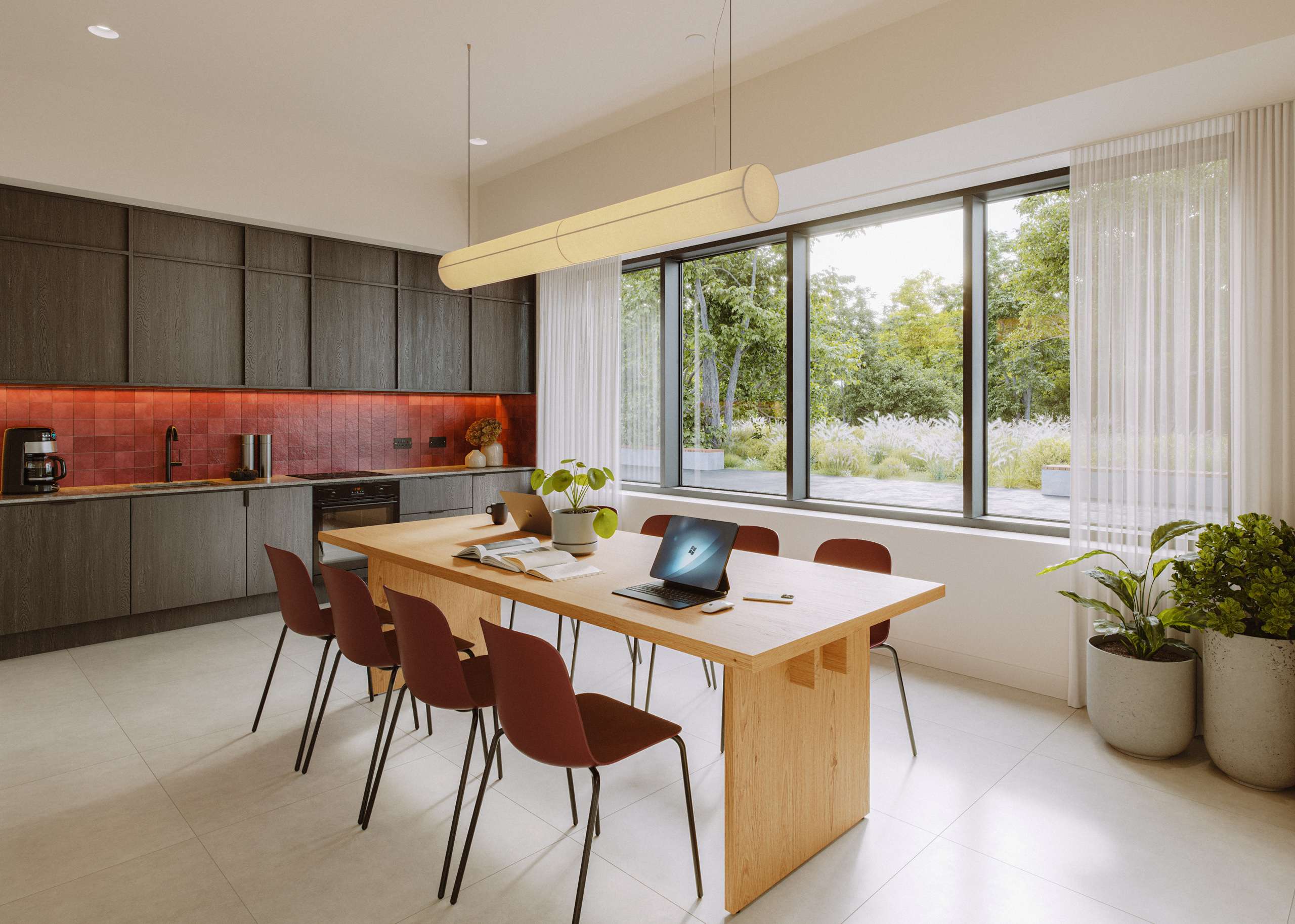 3D rendering of a shared kitchen and dining table with red chairs