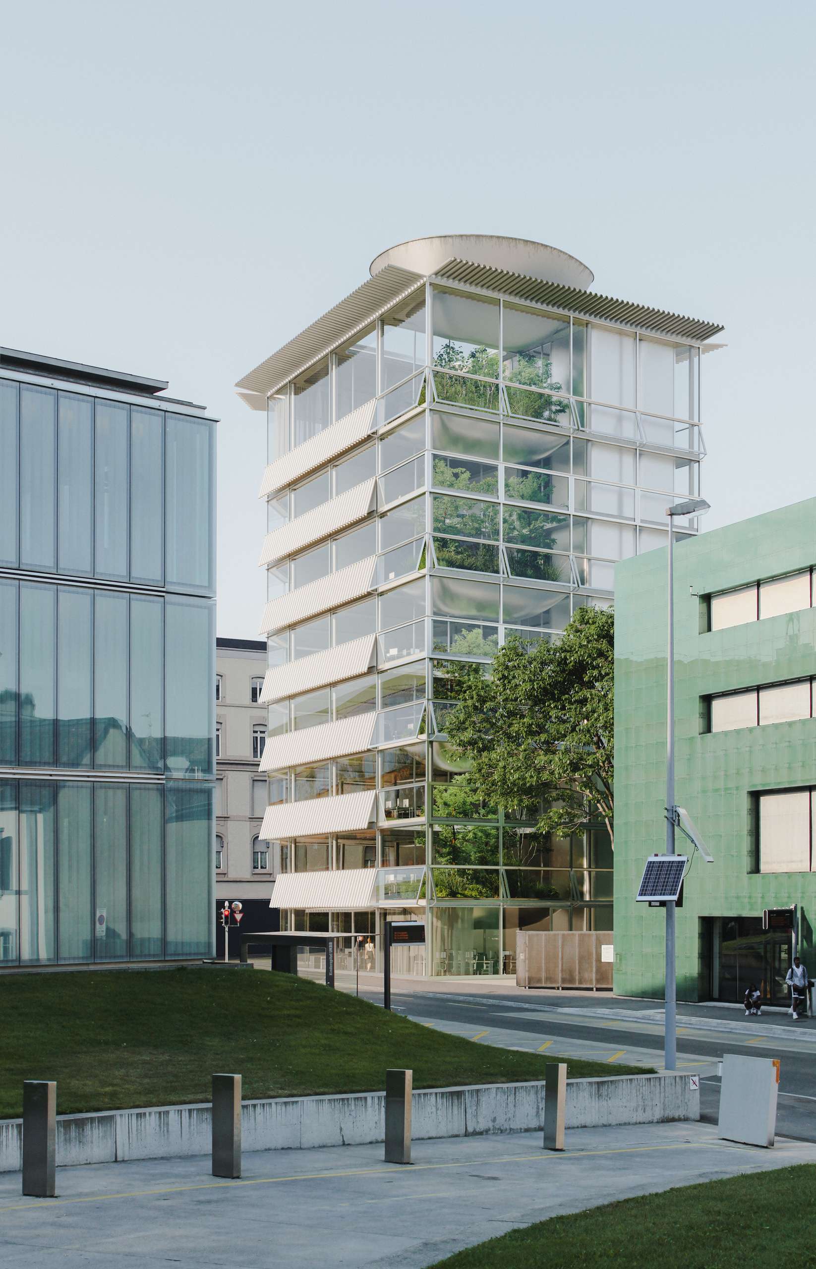 3D rendering of a slender glass office tower among existing buildings in Basel
