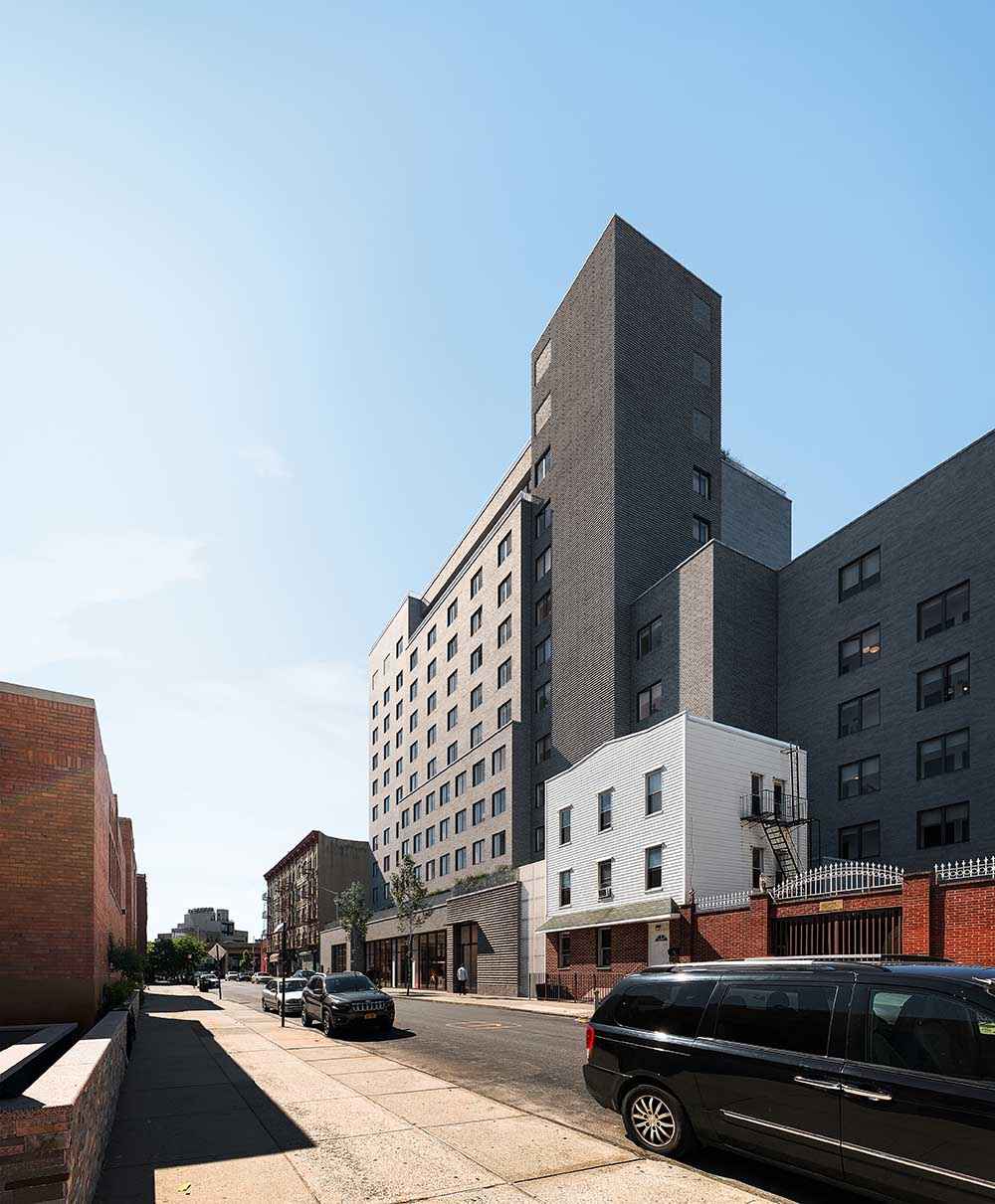 Photorealistic exterior 3D Rendering of a modern co-living building in Williamsburg, New York. Architectural project designed by The Collective with a contemporary facade design made of brick. Real Estate project. Still CG Image produced by Scuares, an architectural visualization studio