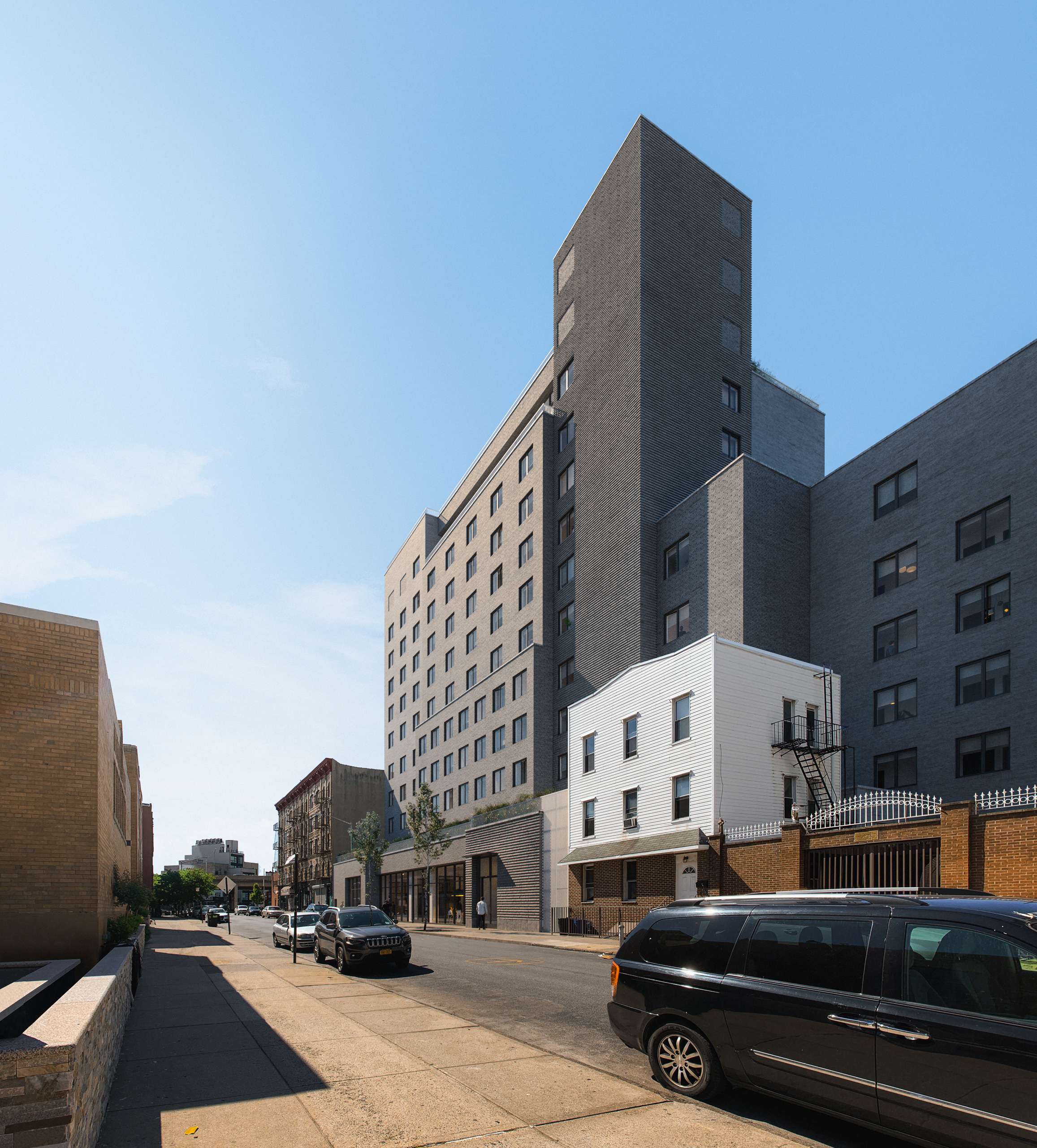 Photorealistic exterior 3D Rendering of a modern co-living building in Williamsburg, New York. Architectural project designed by The Collective with a contemporary facade design made of brick. Real Estate project. Still CG Image produced by Scuares, an architectural visualization studio