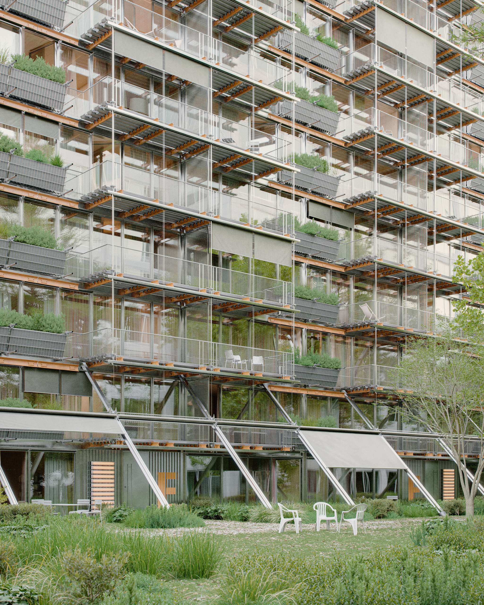 3D rendering of planted apartment balconies above a grassy communal terrace