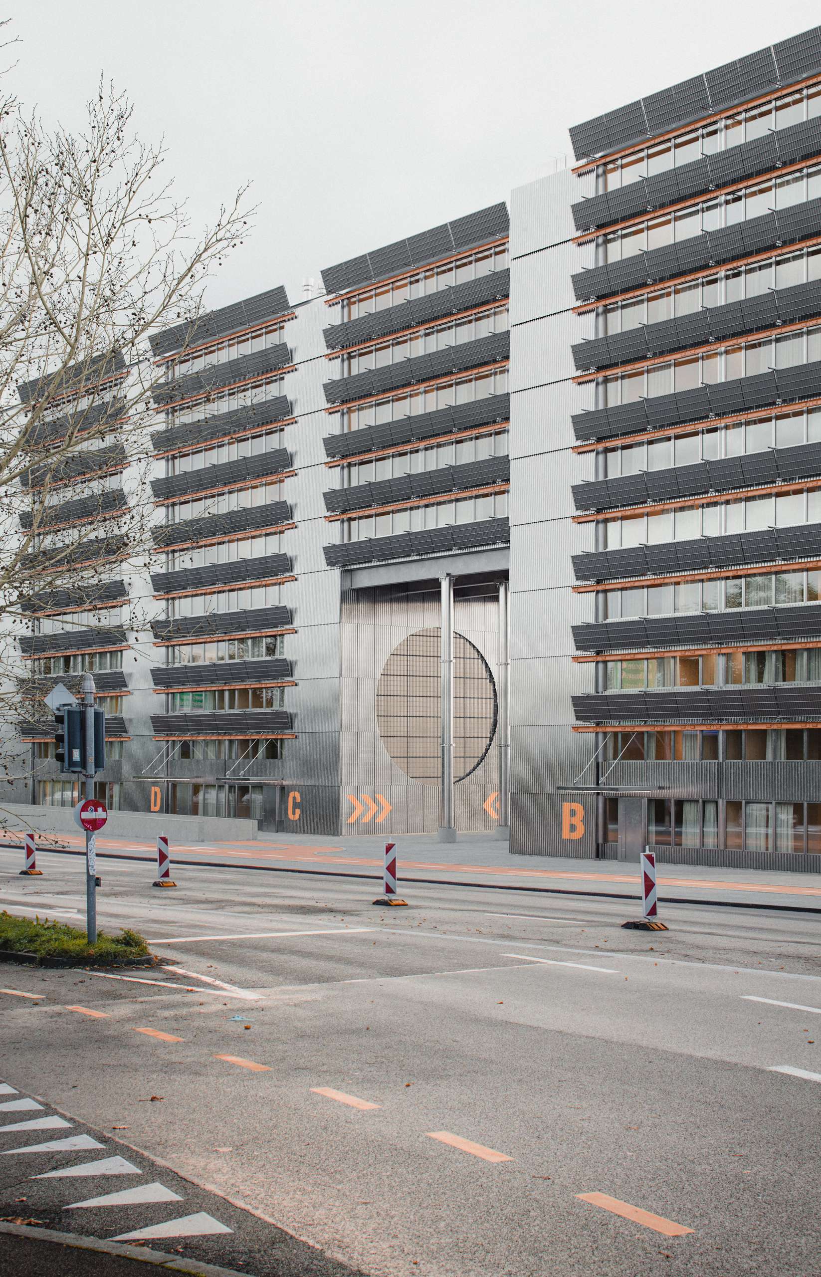 Street-level 3D rendering of a housing façade with a large circular entrance